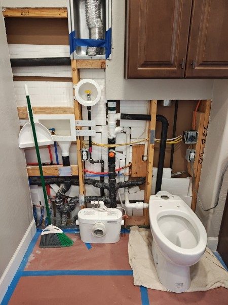 Before: laundry room wall opened to the studs with plumbing exposed