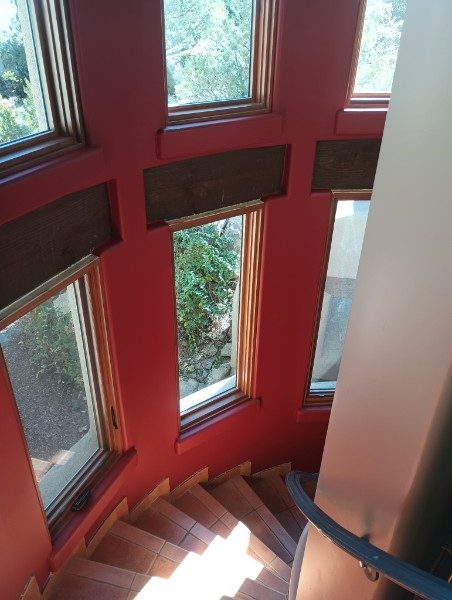Curved stairwell walls finished and painted deep red in an Arizona home